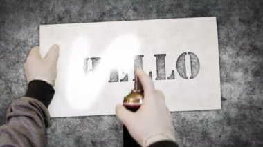 Beton duvara yazı spreyi boyanmış. Graffiti konsepti sanat hoş geldin alıntısı ve olumlu karşılama ikonu. Elinde şablonu olan bir boya. Şehir soyut sanat eserleri.