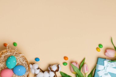 Bej arka planda paskalya kompozisyonu. Fotokopi alanı düz olan üst görünüm pankartı yatar.