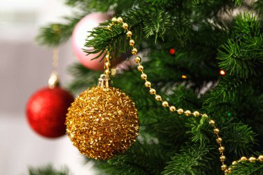 Toplar ve boncuklarla süslenmiş bir Noel ağacına yakın çekim.