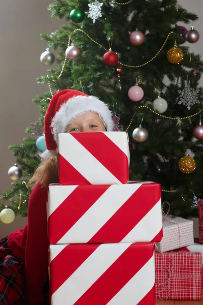 Vtipné Dítě Klobouku Santa Clause Schovává Hromadu Vánočních Krabic Dárky — Stock fotografie