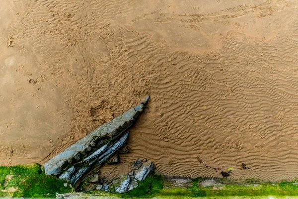 砂浜の質感と石の部分的に見える — ストック写真