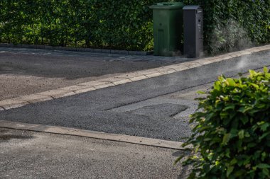 Küçük bir sokakta hala sıcak asfalt var..