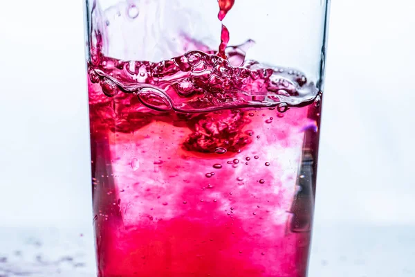 Röd Vätska Hälls Ett Glas Vit Bakgrund — Stockfoto