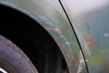 Gri bir kiralık arabanın tekerlek kemerinde ayak izleri var.