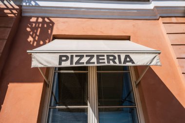 Turuncu duvar binasında restoran pizzacısı tabelası