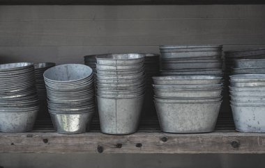 Rafta istiflenmiş galvanize metal saksılar