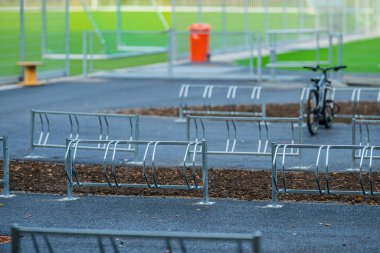 Spor sahasının yanındaki boş metal rafta park edilmiş tek bir bisiklet.