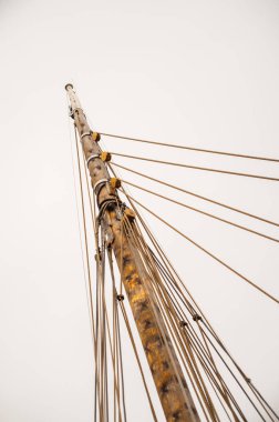 Arka planda liman binaları olan yelkenli gemisinde karmaşık donanım.