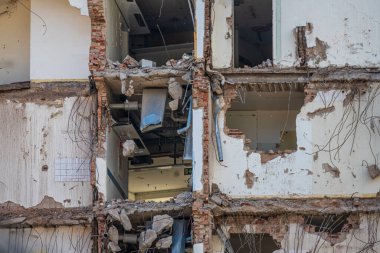 Yıkılmış alandan sarkan iç duvarlar ve kablolar