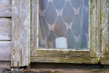 Terk edilmiş bir evin penceresinde mum.