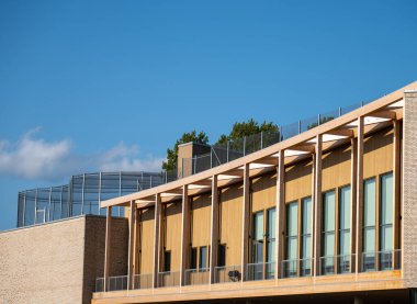 Büyük pencereli ve mavi gökyüzü olan modern ahşap bina