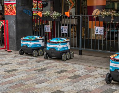 Helsinki, Finlandiya - 05 Ağustos 2025: Restoranın önüne park edilmiş otonom dağıtım robotları