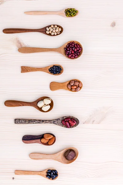 Assortment of beans and lentils in wooden spoon set up on wooden — Zdjęcie stockowe