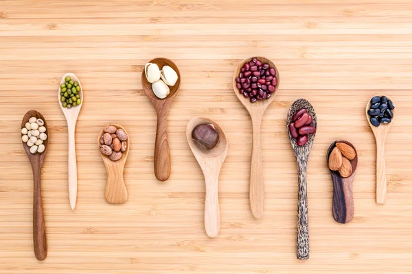Assortment of beans and lentils in wooden spoon set up on wooden — 스톡 사진