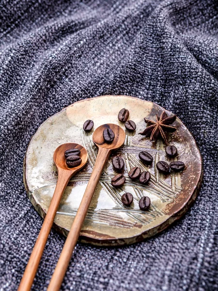 Coffee beans and star anise in ceramic plate with wooden spoons — Stock Photo, Image