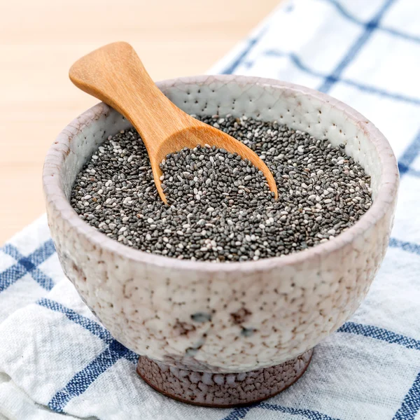 Näringsrikt chia frön i keramikskål med träsked för kost — Stockfoto