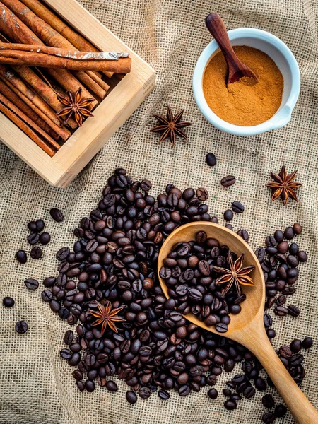 Koppen kaffebönor på duken säck med kanel pinnar , — Stockfoto