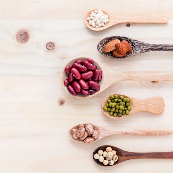 Surtido de frijoles y lentejas en cuchara de madera sobre fondo de madera — Foto de Stock