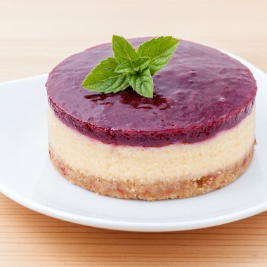 Ahşap arka plan üzerinde yaban mersinli cheesecake ile taze nane yaprakları