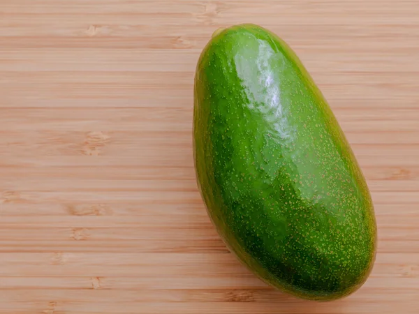 Färsk avokado på trä bakgrund. Ekologisk avocado hälsosam mat — Stockfoto