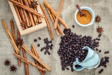 Tarçın çubukları ile bez çuval üzerinde kahve çekirdekleri Fincan ,