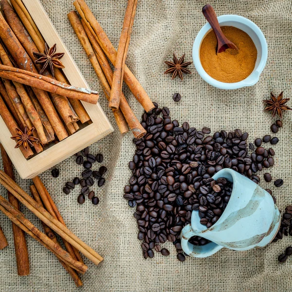 The Cup of coffee beans on the cloth sack with cinnamon sticks , — Stock Photo, Image