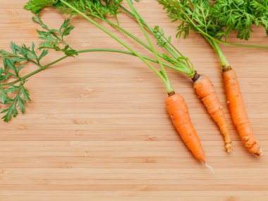 Ahşap masa üzerinde taze havuç grup. Kuyruk ile taze çiğ havuç