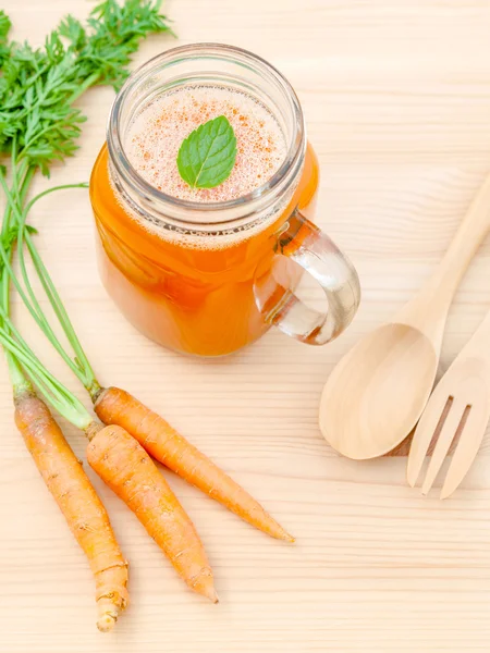 Gelas jus wortel dengan akar wortel pada background.G kayu — Stok Foto