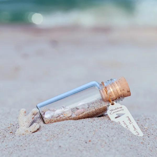 Fechar garrafa de convite de casamento com concha do mar e papel — Fotografia de Stock