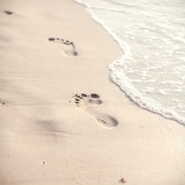 Foco suave e tom de pegadas na areia da praia tropical sagacidade — Fotografia de Stock