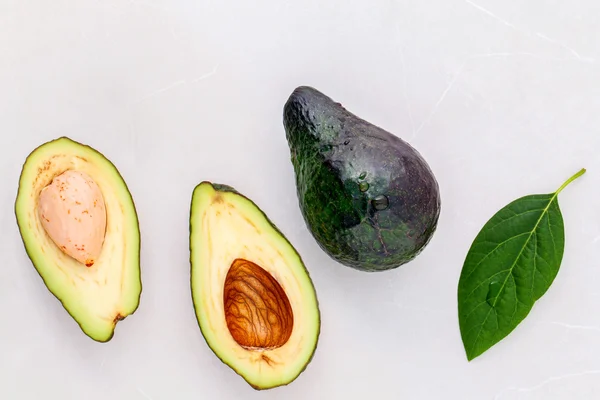 Concepto de comida saludable. Primer plano aguacate fresco y hojas en marbl — Foto de Stock