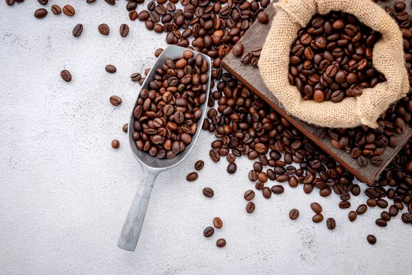 Rostade Kaffebönor Med Skopor Inställning Vit Betong Bakgrund — Stockfoto