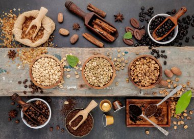 Kahve arkaplanı, kavrulmuş kahve çekirdekleri ve koyu taştan arka planda lezzetli kahve yapmak için lezzetli malzemeler..