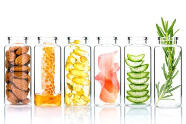 Homemade skin care with natural ingredients and herbs in glass bottles isolate on white background.