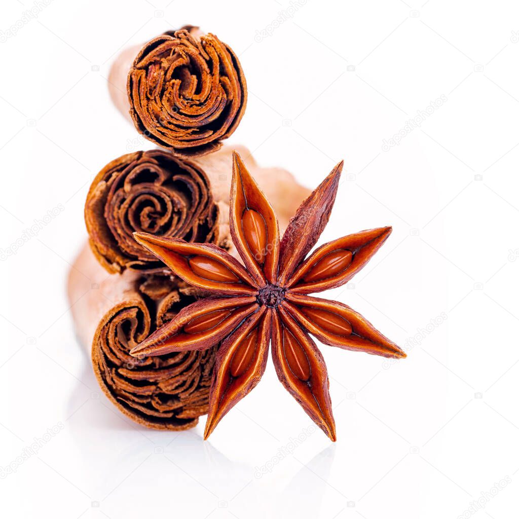 Ceylon cinnamon sticks and anise star isolated on white background .
