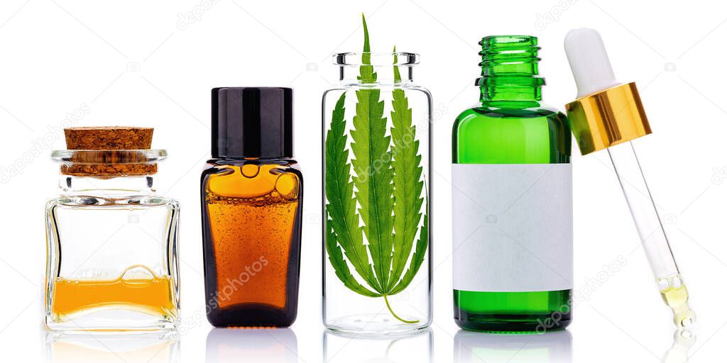 Glass bottles of cannabis oil and hemp leaves isolated on white background. Concept of using hemp in medicine