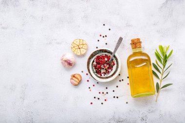 Beyaz beton arka planda cam zeytinyağı ve zeytin dalı..