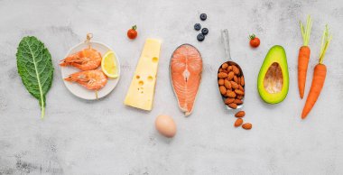 Ketojenik düşük karbonhidrat diyet konsepti. Beyaz beton arkaplan üzerine kurulmuş sağlıklı yiyecekler seçimi için gerekenler.