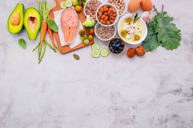 Ketojenik düşük karbonhidrat diyet konsepti. Beyaz beton arkaplan üzerine kurulmuş sağlıklı yiyecekler seçimi için gerekenler.