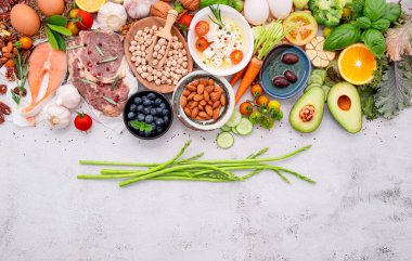 Ketojenik düşük karbonhidrat diyet konsepti. Beyaz beton arkaplan üzerine kurulmuş sağlıklı yiyecekler seçimi için gerekenler.