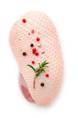 Beyaz arka planda izole edilmiş biberiye ve baharatlı çiğ ördek göğsü filetosu..