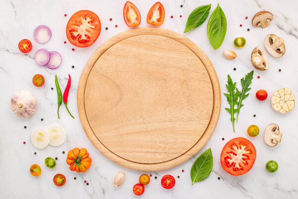 The ingredients for homemade pizza set up on white marble background.