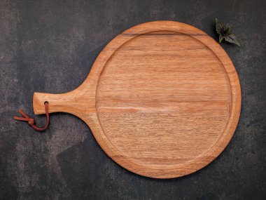 Koyu betona kurulmuş boş ahşap pizza tabağı. Koyu beton zemin üzerinde pizza tepsisi düz ve kopyala.