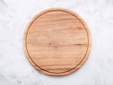 Beyaz betona kurulmuş boş ahşap pizza tabağı. Beyaz beton zemin üzerinde pizza tahtası düz ve kopyala.