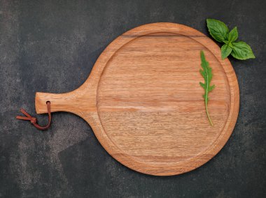 Koyu betona kurulmuş boş ahşap pizza tabağı. Koyu beton zemin üzerinde pizza tepsisi düz ve kopyala.