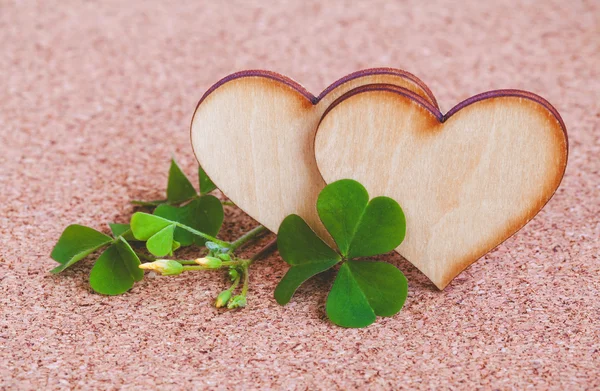 Closeup clover leaf and stone ,wooden heart on cork background. — Stock Photo, Image