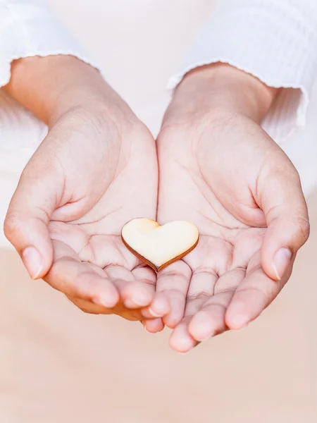 Mädchen mit einer Herzform aus Holz. Konzept für das Schenken von Liebe. — Stockfoto