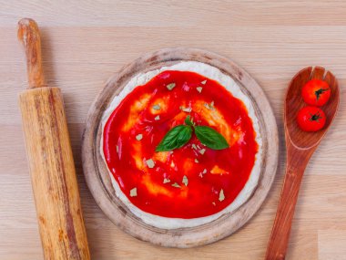 Pizza hamuru ile domates sosu hazırlama ahşap tablo