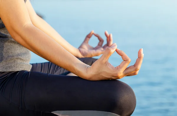 La mujer meditando en una pose de yoga en la playa tropical . — Foto de Stock