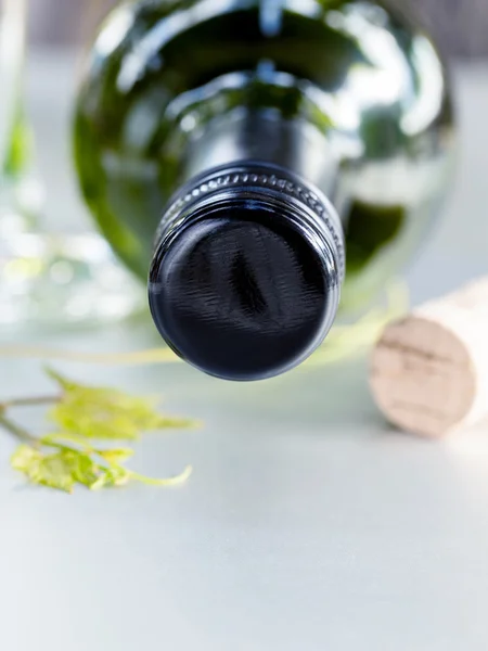 Wine bottle with vine and wine cork put on the board. — Stock Photo, Image